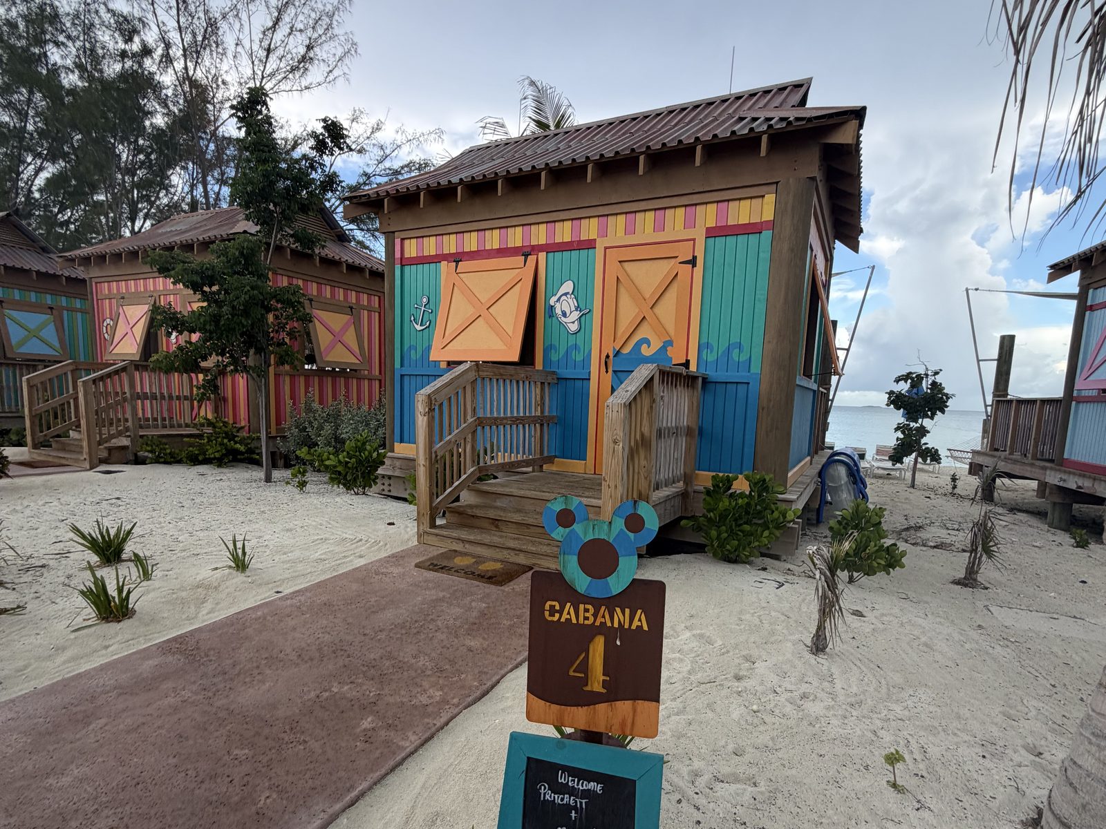 A bright family cabana at Castaway Cay, its number sign on the path
