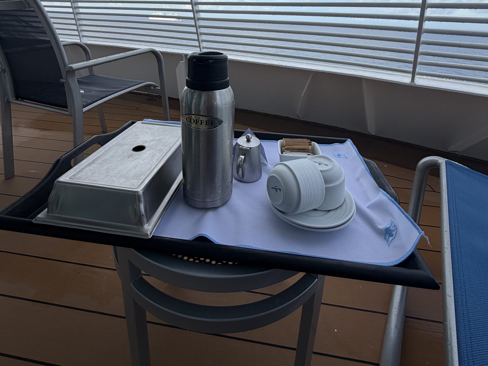 A room-service coffee tray on a verandah table in the morning sun