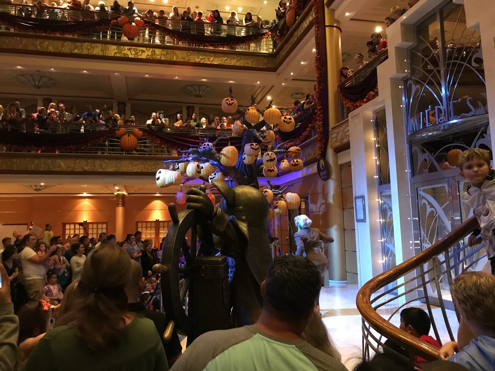 The pumpkin tree glowing in the ship's atrium at the lighting party, every railing lined with guests