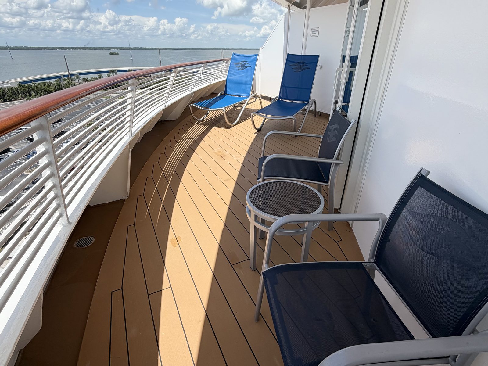 A curved aft verandah with its loungers and chairs, the sea beyond the rail