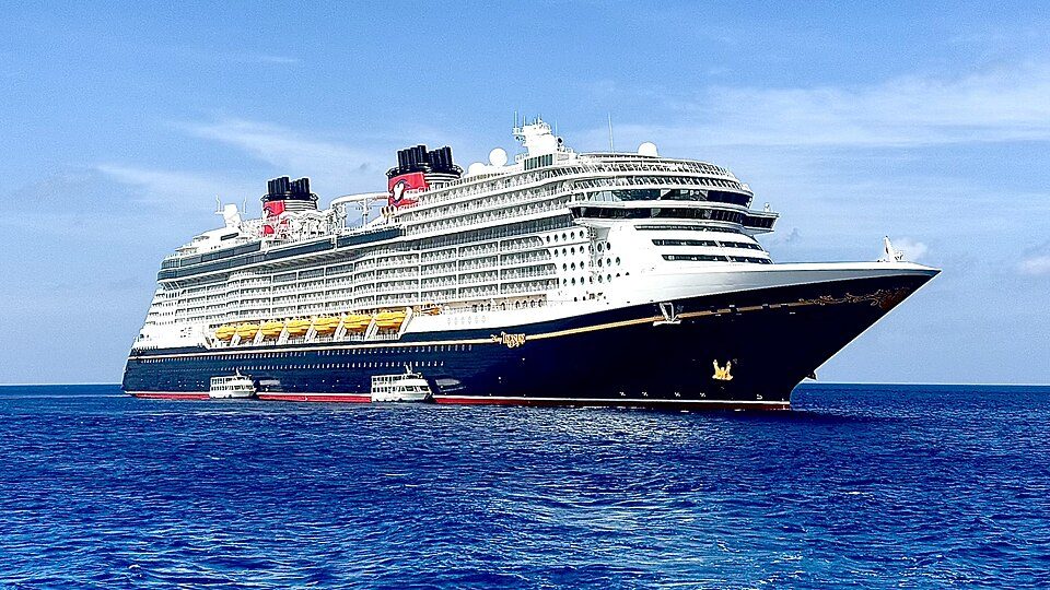 The Disney Treasure under way on a blue sea, seen from the bow